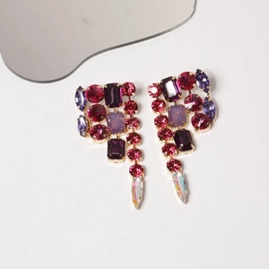 Detailed view of colorful multi-shape zircon tassel earrings on a sleek gold setting