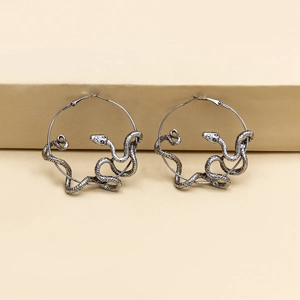 Vintage snake-shaped hoop earrings in antique silver finish on a minimalist background