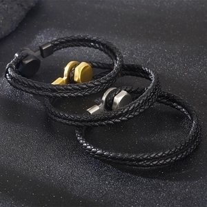 Detailed view of woven leather bracelets with gold, silver, and black metal clasps
