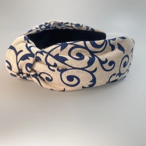Detail of linen-blend wide headband featuring navy blue baroque floral prints and a top knot
