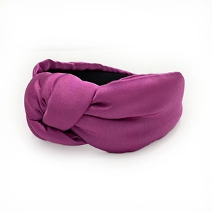 Detail showing the burgundy silk satin fabric texture and knotted design of the headband