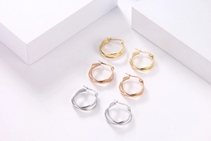 Tre paia di orecchini a doppio cerchio geometrico in oro, oro rosa e argento