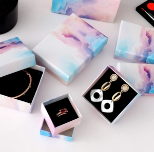 Macro detail of gradient jewelry boxes with soft blue and pink watercolor textures