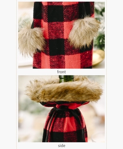 Detail view of red and black plaid wine bottle cover with faux fur trim and pom poms