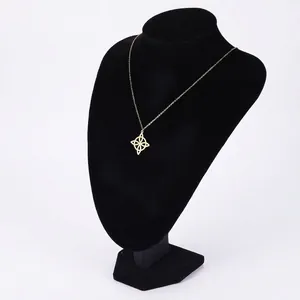 Golden Viking compass pendant necklace with hollow petal design on black velvet display