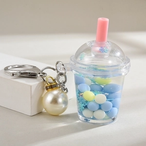 Quicksand bubble tea keychain with blue and yellow glitters and pearl charm