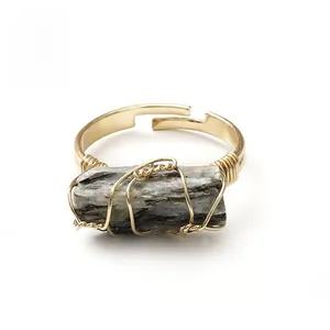 Macro view of adjustable handmade wire-wrapped ring featuring raw grey natural stone