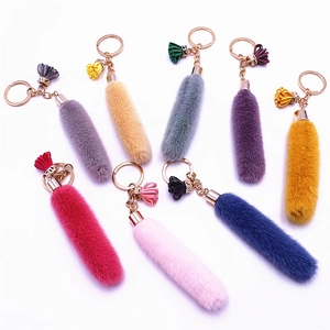 Colorful plush tassel keychains in multiple shades with rose gold rings on white background