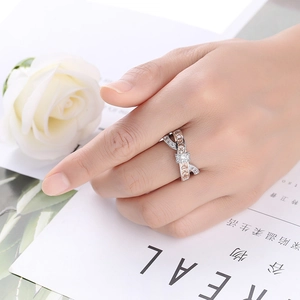 Detail shot of a mixed-metal ribbon ring with pave zircon stones on a female finger