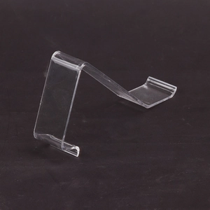 Clear acrylic shoe display stand for retail shop with minimalist geometric curved design