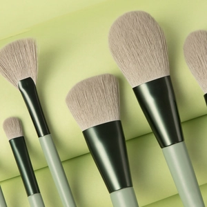 Close-up of 8-piece green makeup brush set with soft bristles on pastel background