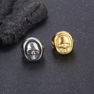 Punk style stainless steel skull rings for men in silver and gold finishes shown at 45-degree angle