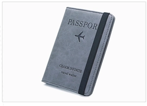 Detailed close-up of dark grey frosted leather passport holder with elastic strap