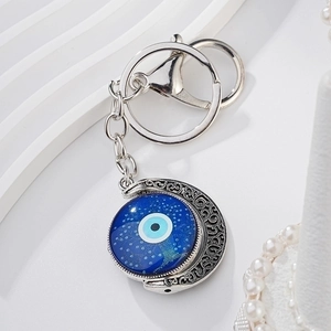 Turkish blue evil eye keychain with silver crescent moon pendant on a white background