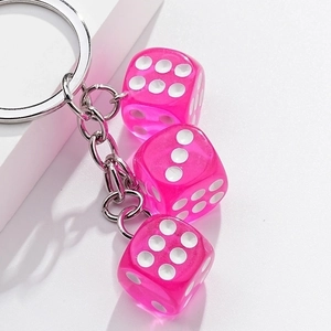 Pink translucent dice keychain with metallic ring and white dots on three dice