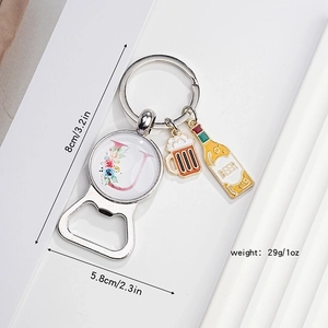 Close-up of beer bottle opener keychain with floral letter J and enamel beer charms