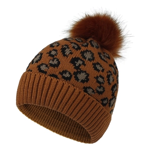 Detail of warm leopard print knit beanie with large brown faux fur pom pom and folded cuff
