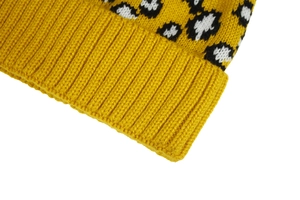 Close-up of yellow knit beanie featuring leopard print patterns and ribbed texture details