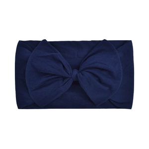 Detail view of a soft navy blue nylon baby headband featuring a large fabric bow