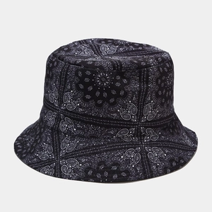 Detailed close-up of a cotton bucket hat with white paisley pattern on black fabric