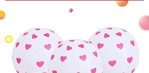 Close-up of white latex balloons with pink heart prints for romantic wedding decor