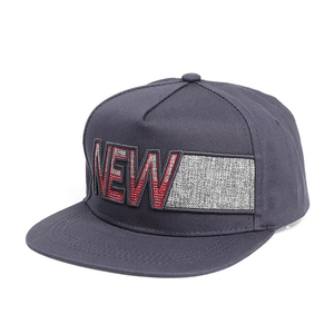 Détail de la broderie de lettres NEW sur une casquette snapback grise à bord plat