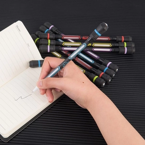 Detail showing hand holding a professional spinning pen for finger balance over a notebook