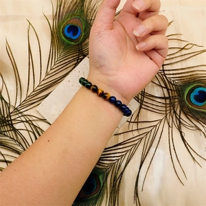 Close-up of 8-10mm natural tiger eye and malachite beaded bracelets on wrist with feathers