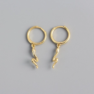 Detail view of gold snake earrings featuring sparkling stones and high-polish finish
