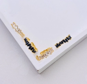 Detailed view of gold hoop earrings with baguette-cut black and clear crystals
