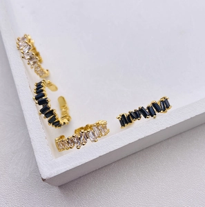 Macro shot of minimalist gold rings featuring black and white rectangular cubic zirconia stones