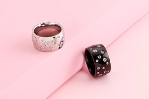 Close-up of wide stainless steel band rings with sparkling pave set crystals in silver and black