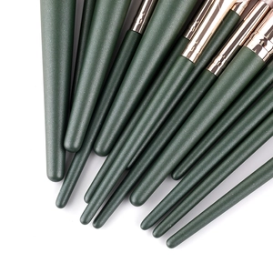 Dark green makeup brush set with matte handles and rose gold ferrules on white background