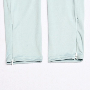 Detail shot of light blue trousers featuring hidden zippers on the side ankle hems