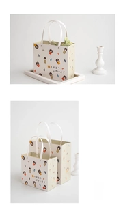 Detail of white Japanese Kokeshi doll paper gift bag with soft flat rope handles