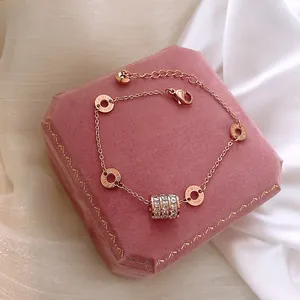 Detail view of rose gold bracelet with zircon pendant on pink velvet jewelry box