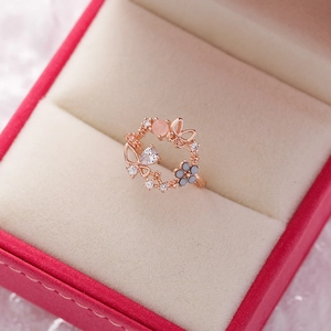 Macro detail of a rose gold flower ring with butterfly motifs and sparkling zircons