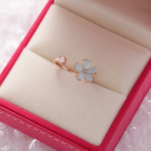 Detailed macro view of a rose gold flower ring with blue petals and white zircon