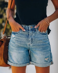 Détail d'un short en jean bleu clair délavé avec trous usés et ourlets repliés sur mannequin