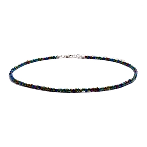 Detail of colorful beaded necklace featuring a silver lobster clasp and extension chain