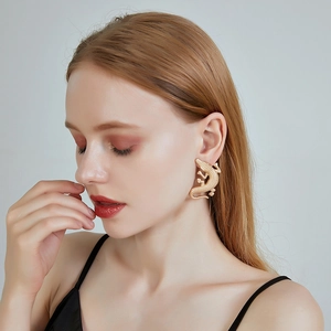Detailed close-up of a gold-plated lizard earring featuring intricate scale textures
