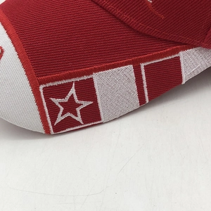 Detail of white star embroidery on red and white canvas baseball cap with rich texture