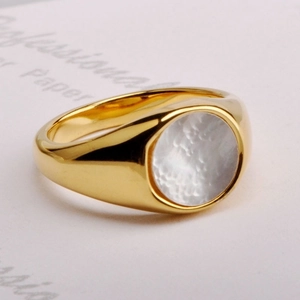 Detail of a vintage golden signet ring featuring a polished round white shell inlay