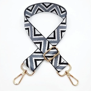 Close-up of adjustable woven shoulder strap with black and white geometric V-patterns