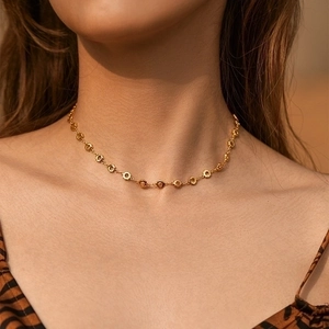 Minimalist gold collar necklace featuring hexagonal flower clusters worn by a model