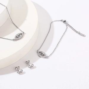 Detailed view of silver stainless steel evil eye necklace, bracelet and earrings set