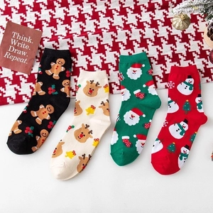 Set of 4 festive Christmas crew socks featuring reindeer and Santa on a winter background