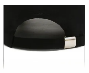 Détail d'une casquette de baseball noire montrant la boucle réglable en métal argenté