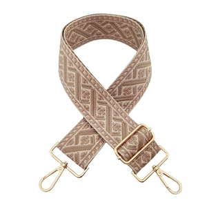 Close-up of khaki woven jacquard wide shoulder strap with gold metal hooks on white background