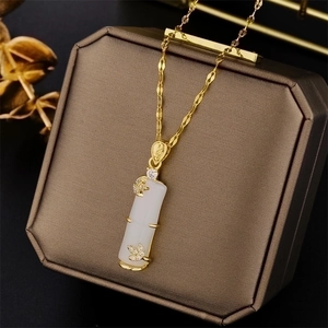 Golden titanium steel necklace with white jade bamboo pendant on a jewelry box